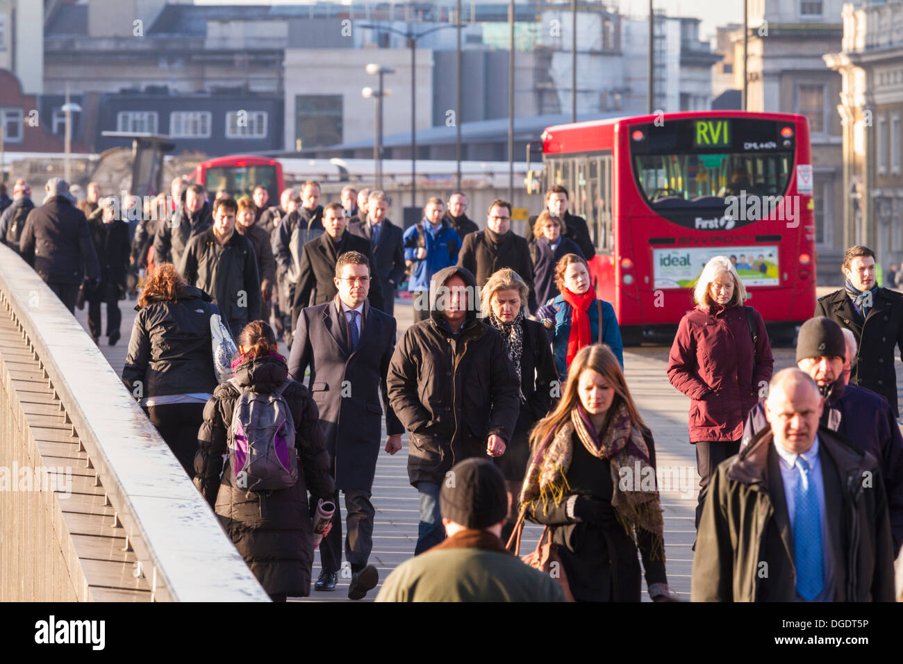La mattina presto pendolari cross London Bridge per la città in un freddo inverno pieno di sole al mattino Foto Stock