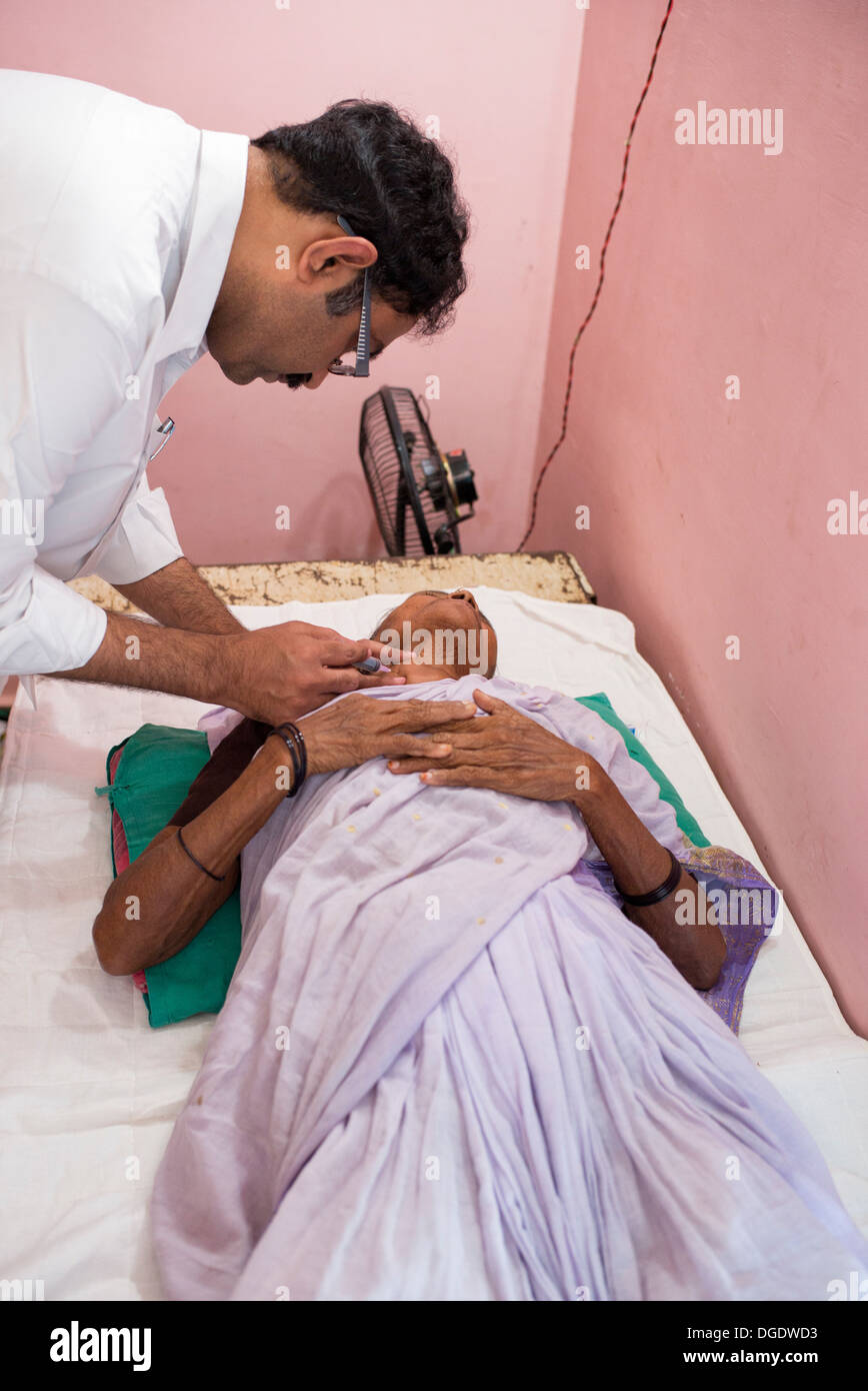 L'aspirazione con ago fine patologo estrazione delle celle in un grumo di un paziente di sesso femminile al Sathya Sai Mobile Ospedale outreach Foto Stock
