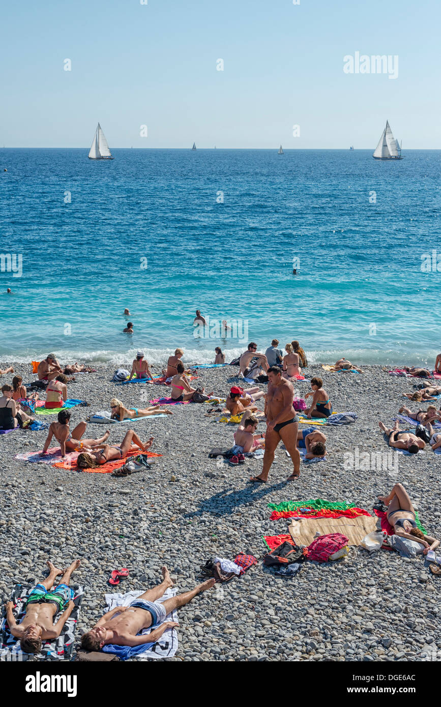 Prendere il sole sulla spiaggia principale di Nizza. Foto Stock