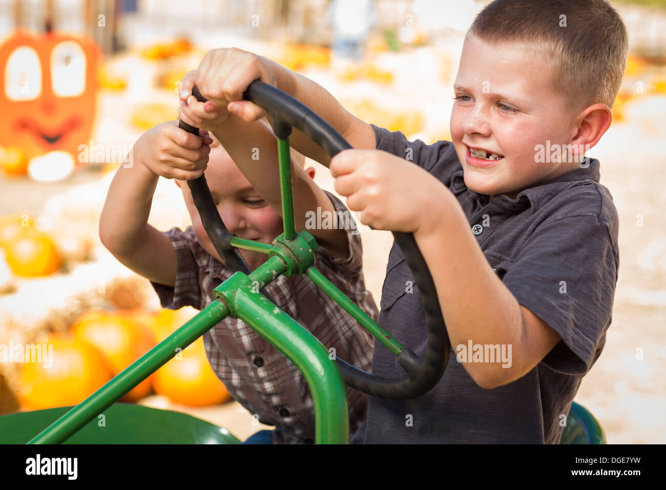 Adorabili ragazzi giocare su un vecchio trattore in un rustico Outdoor rientrano l'impostazione. Foto Stock