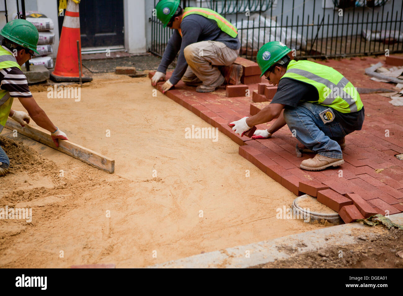 Gli uomini di mattoni di posa sul marciapiede - USA Foto Stock