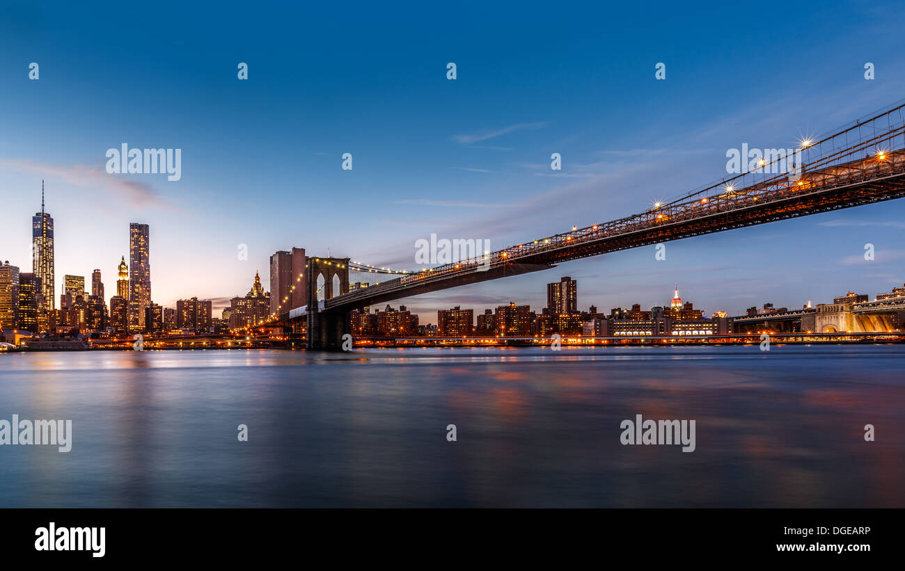 Ponte di Brooklyn Bridge spanning est fiume al tramonto Foto Stock