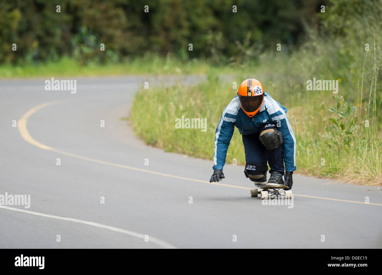 Skateboard longboard giovane formazione in discesa su strada pubblica Foto Stock