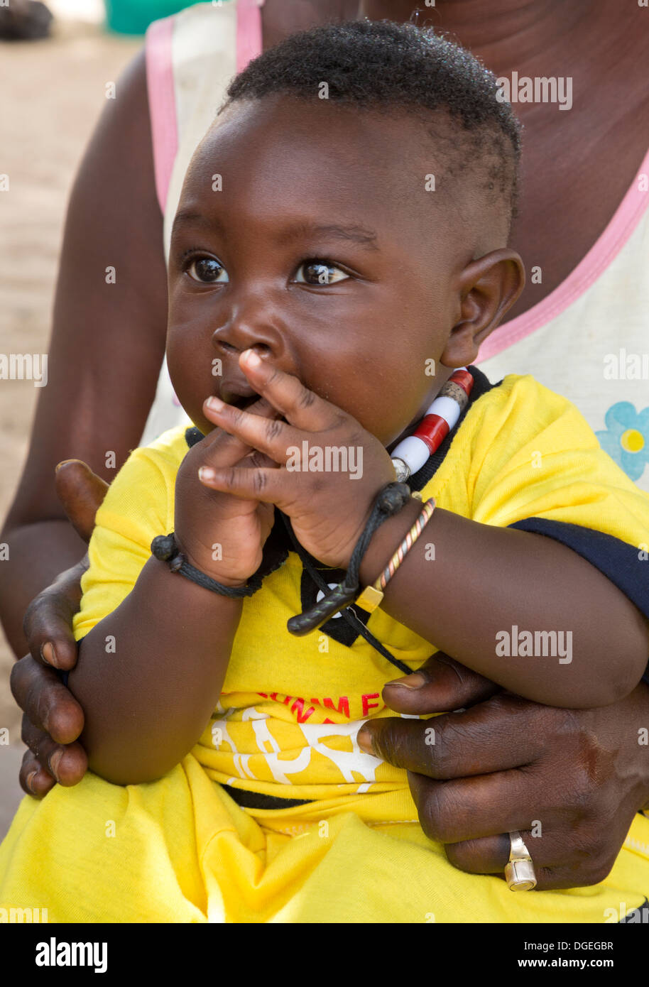 Little Boy nella Madre di giro, Nixo Village, vicino a Sokone, Senegal. Server gruppo etnico. Foto Stock
