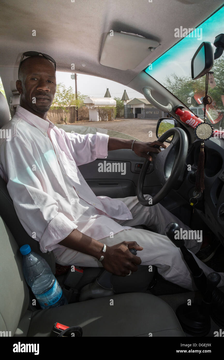 Driver senegalesi con coranici talismano appeso al retrovisore. Kaolack, Senegal. Foto Stock