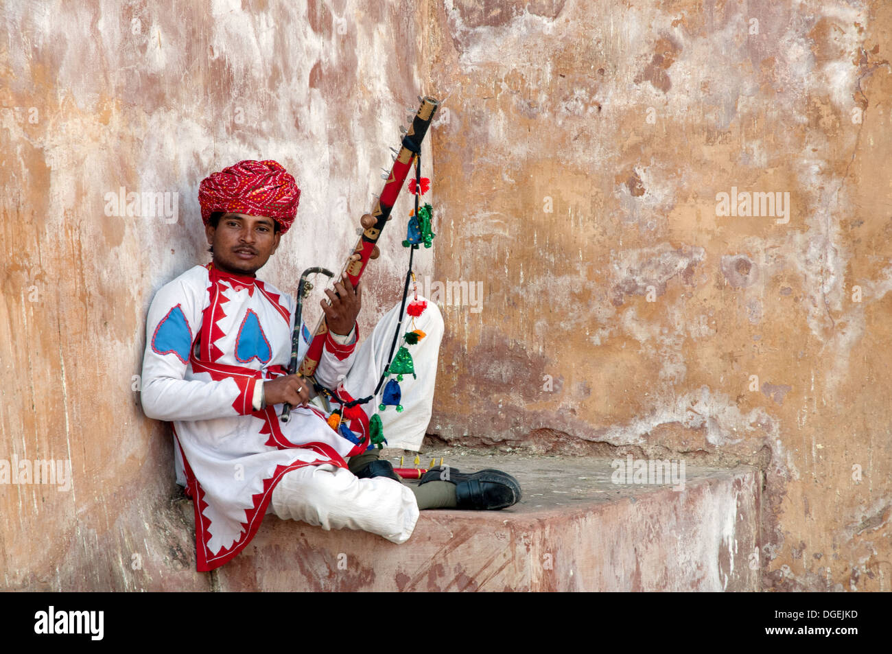 Uomo di Rajasthani che posano con strumento tradizionale all'interno Amer Fort, a Jaipur, India Foto Stock