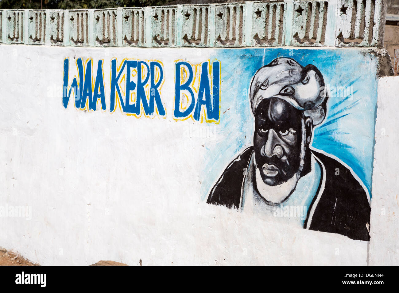Dipinto sul muro di una zona residenziale composto indicante che il residente aderisce ad un particolare capo religioso musulmano. Gambia. Foto Stock