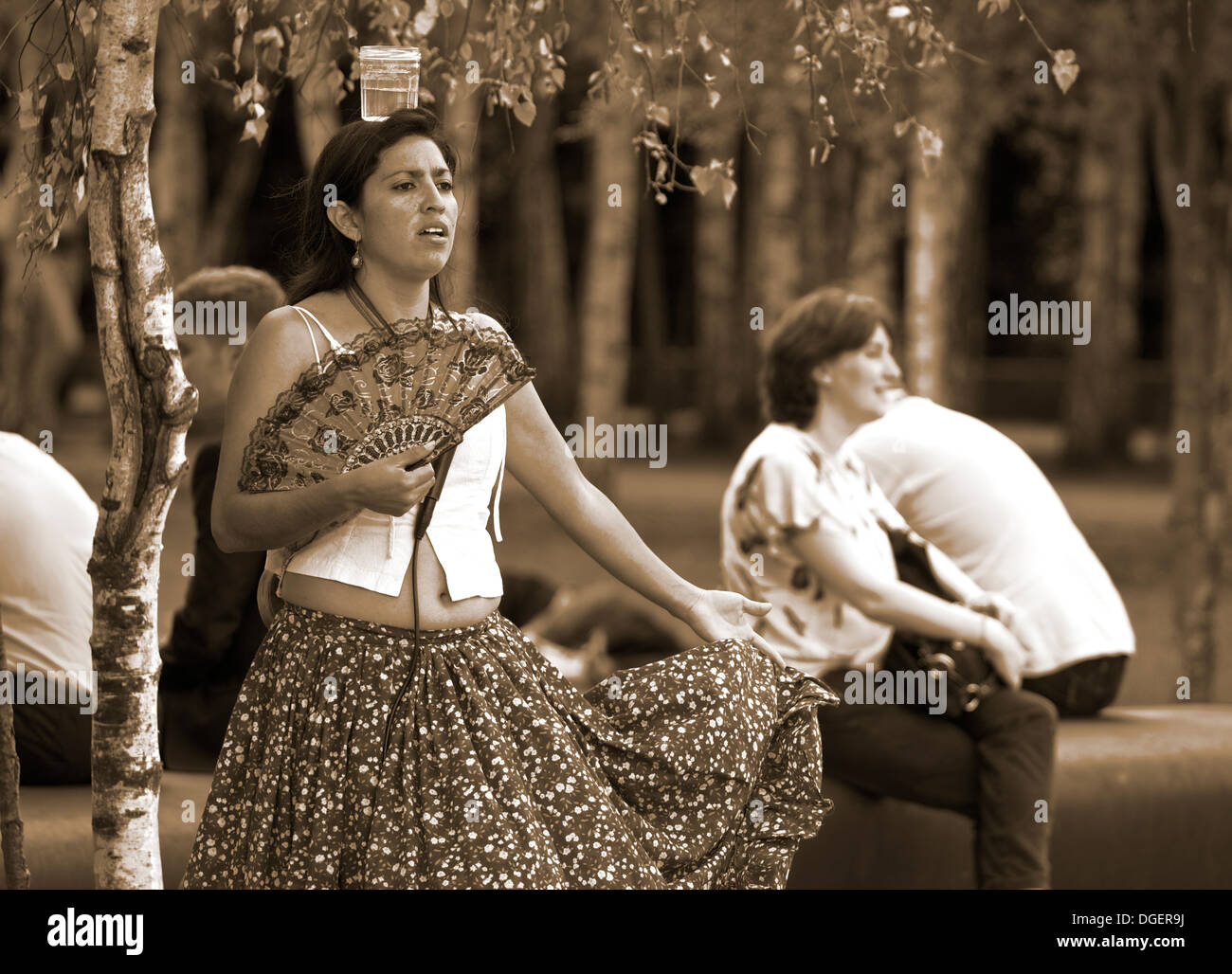 Femmina performer di strada con vetro equilibrato sul suo capo South Bank di Londra Inghilterra Europa Foto Stock