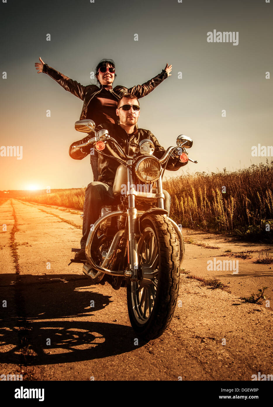 Giovane biker in una giacca di pelle in sella a una motocicletta sulla strada Foto Stock