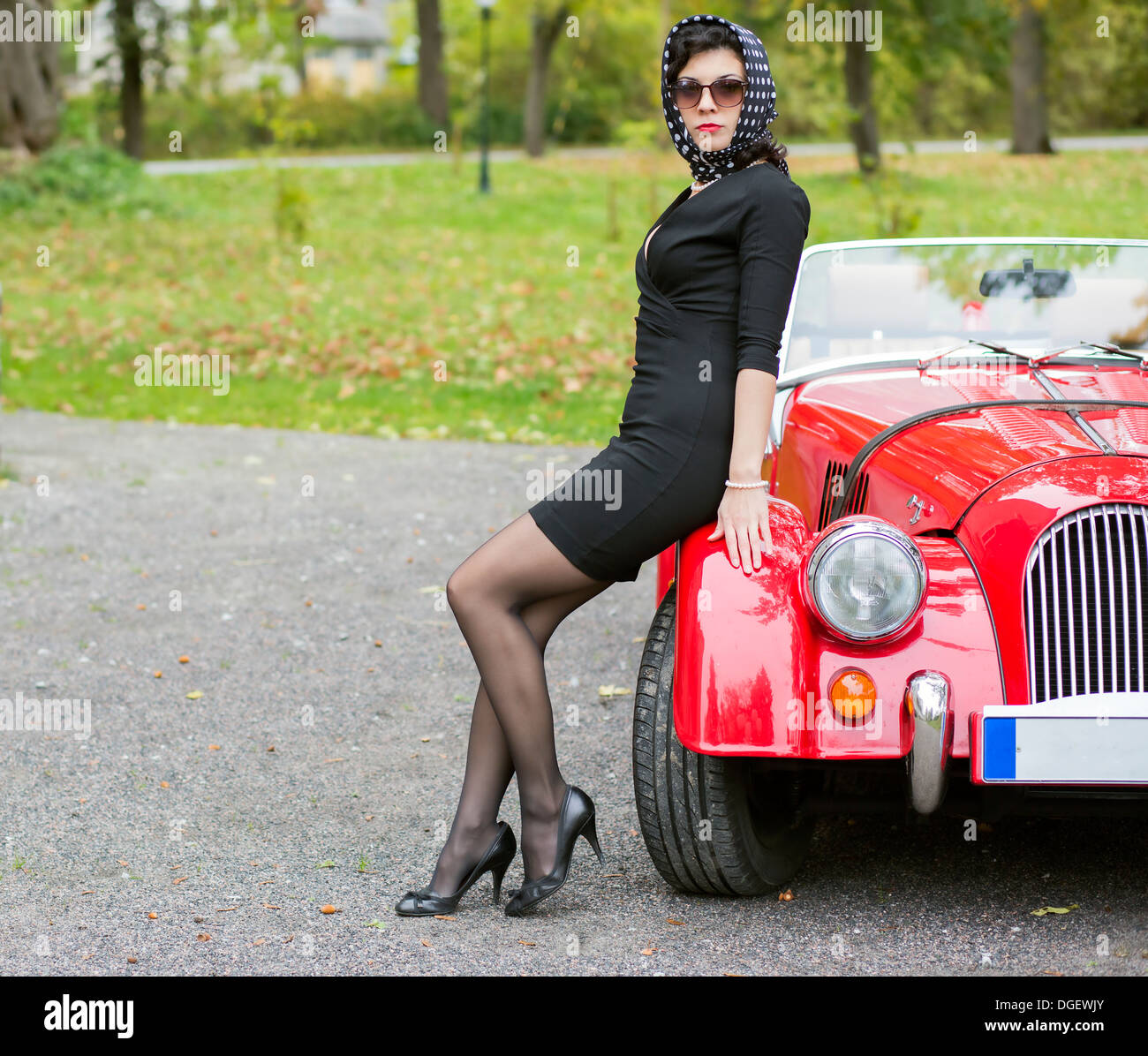 La donna in nero con occhiali scuri con auto Foto Stock