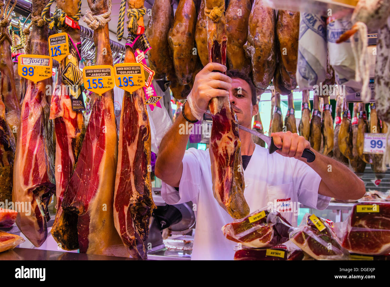 Drogheria durante il taglio di prosciutto spagnolo al Mercato di Boqueria, Barcellona, in Catalogna, Spagna Foto Stock