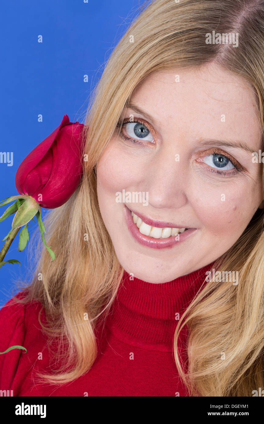 Modello rilasciato. attraente giovane donna tenendo una sola rosa rossa Foto Stock