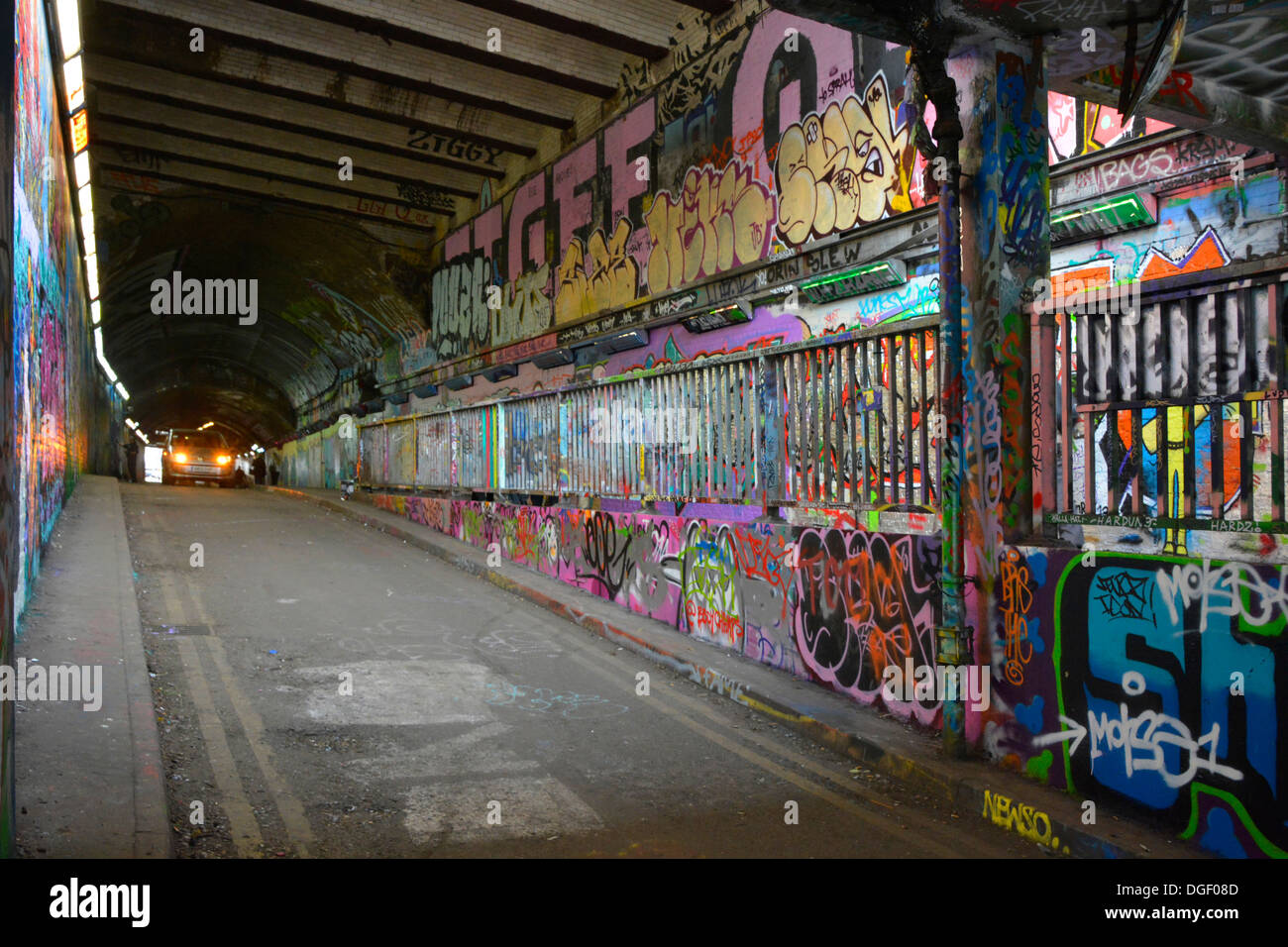 Scena di strada nel tunnel con ampia copertura di graffiti Foto Stock