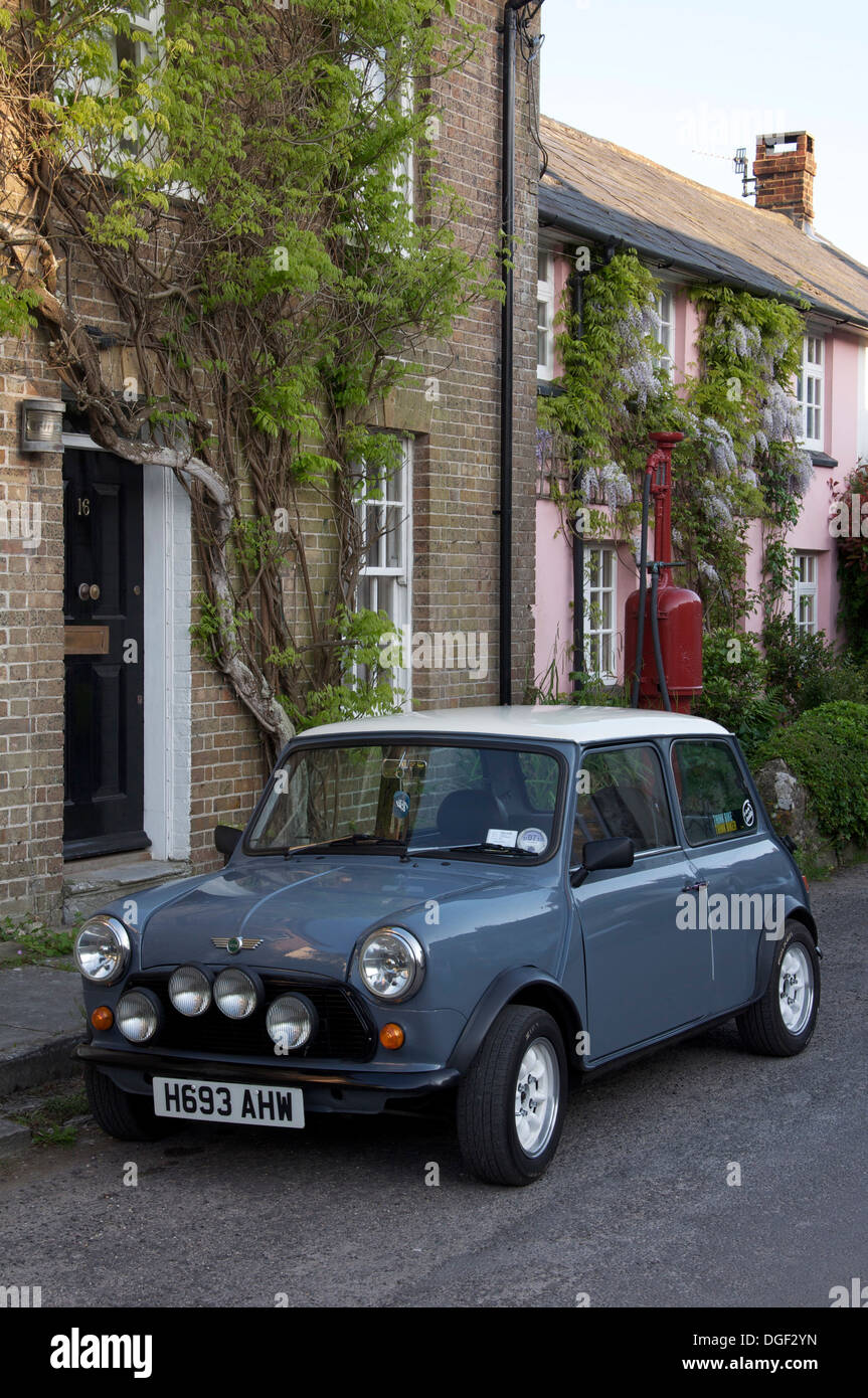 Classic car. Una Austin Mini parcheggiata nella strada alta del pittoresco villaggio di Dorset di Sydling St Nicholas. Dietro di esso è un vintage pompa benzina. In Inghilterra. Foto Stock