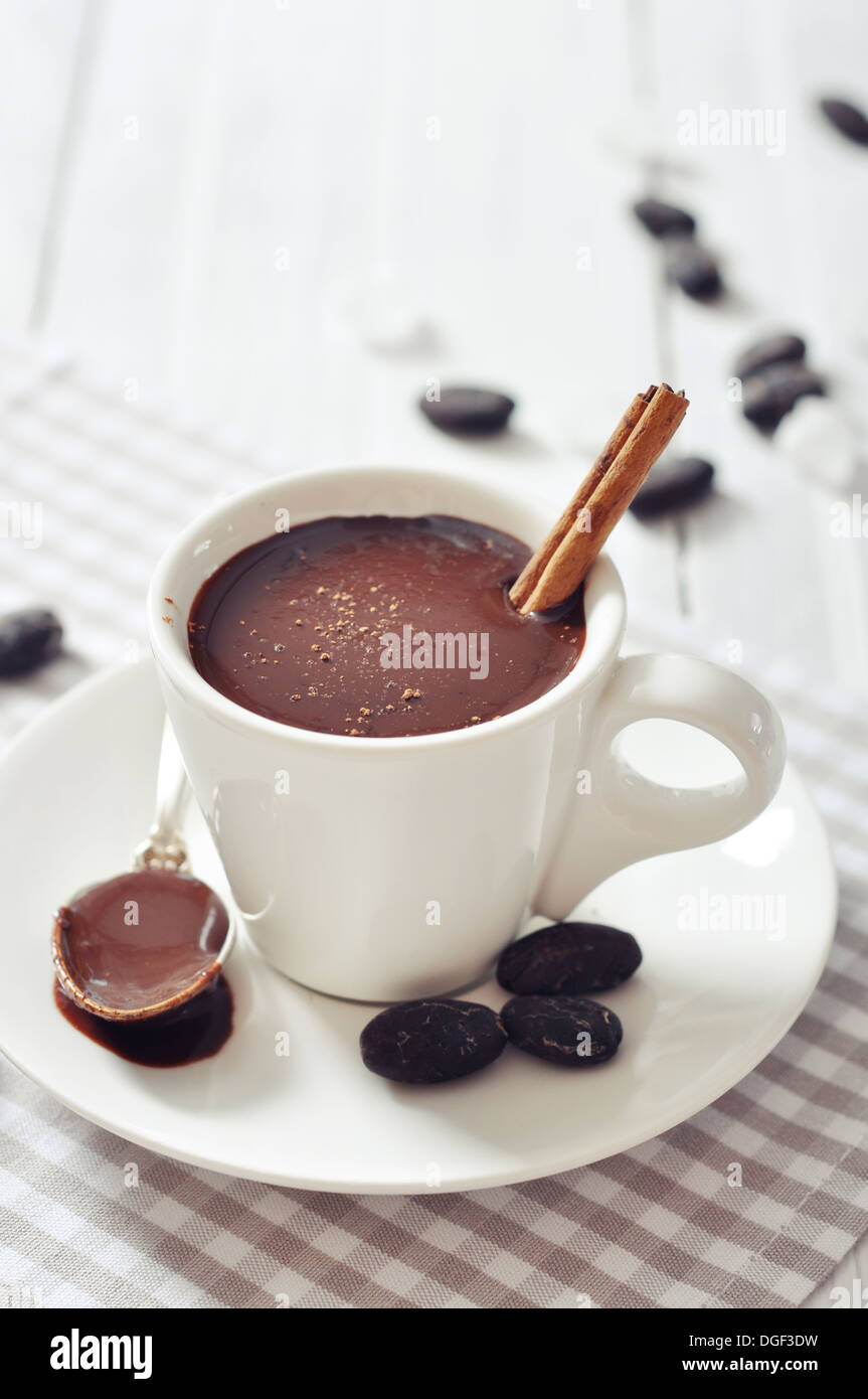 Cioccolata in tazza con polvere di cacao e cannella stick su sfondo di  legno Foto stock - Alamy