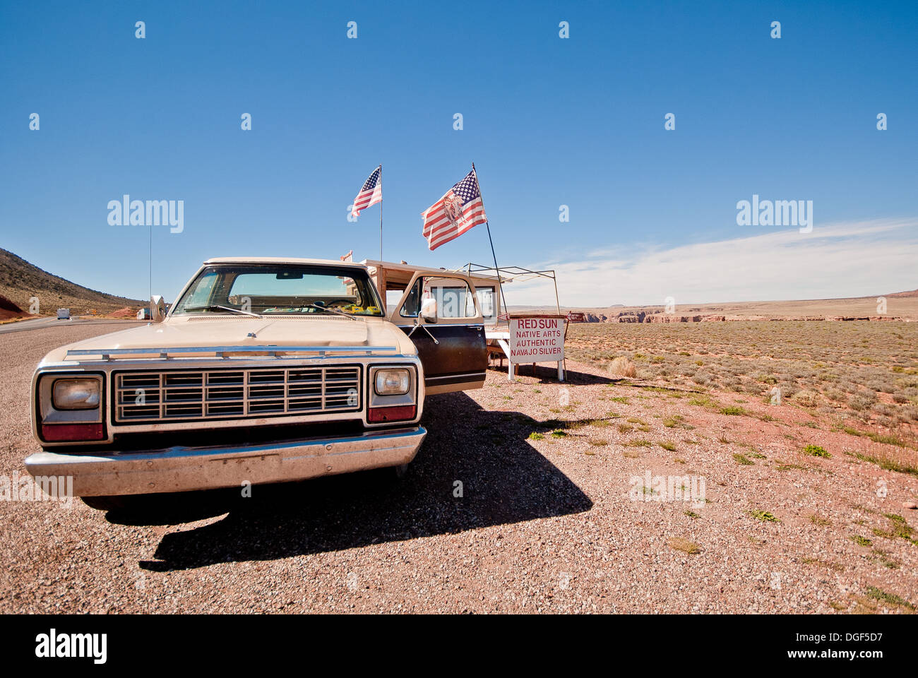 Auto sulla strada nel deserto con la bandiera americana. Foto Stock