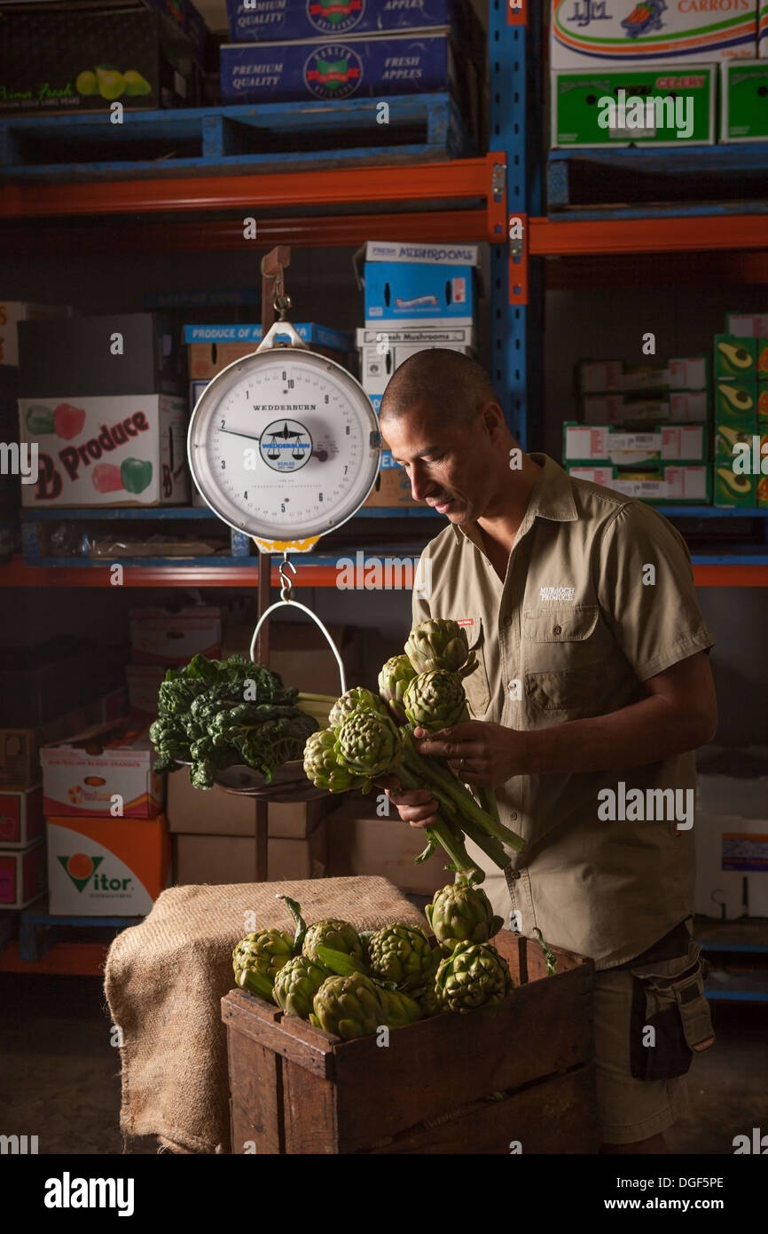 Un uomo del peso di produrre in un magazzino Foto Stock