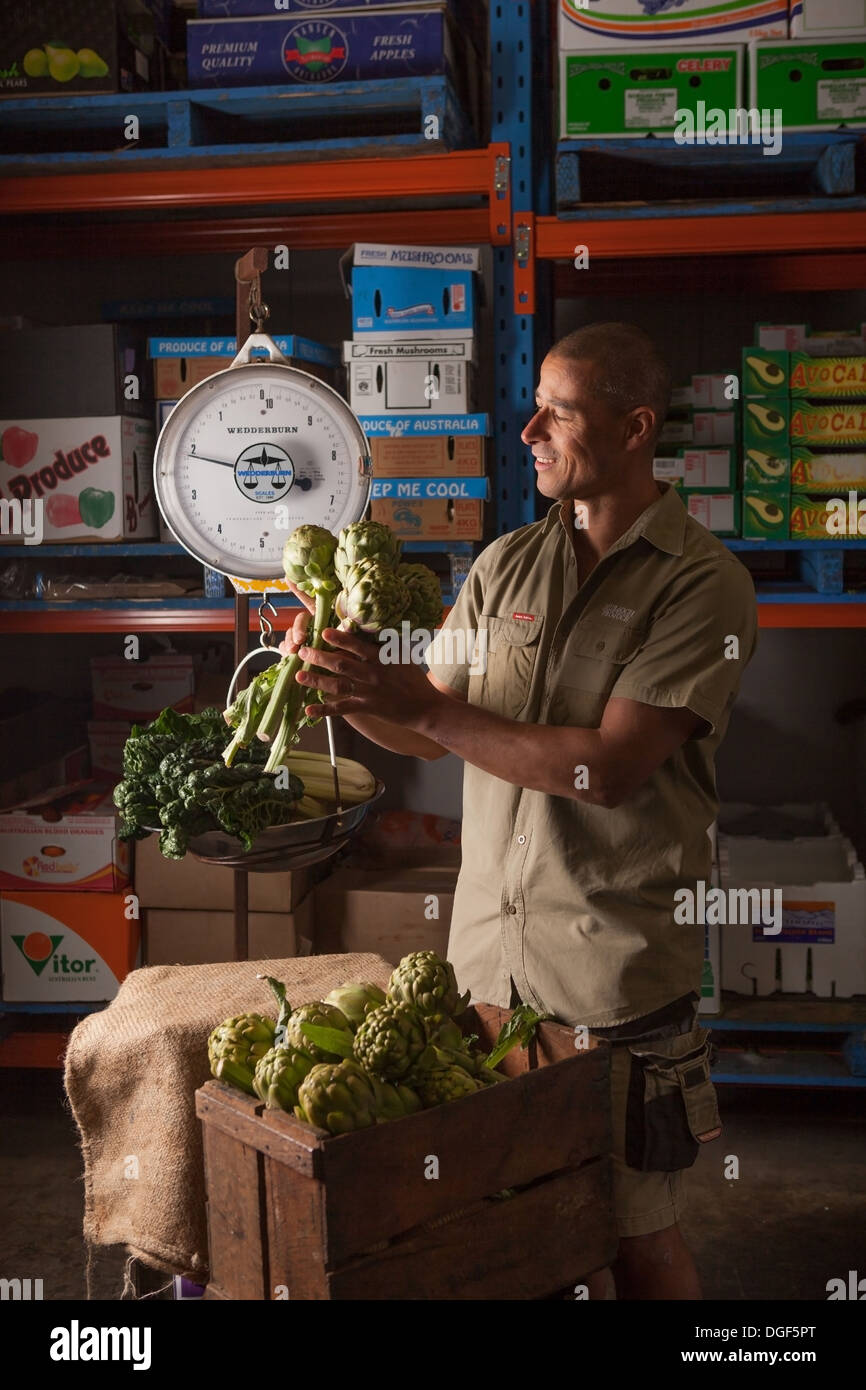 Un uomo del peso di produrre in un magazzino Foto Stock