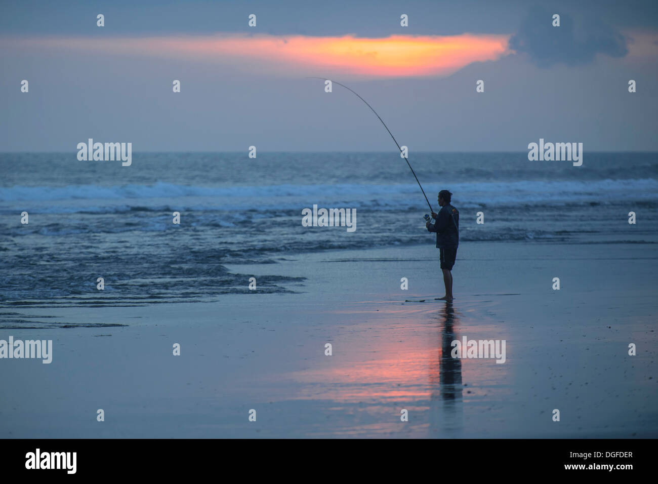 Fisherman permanente sulla spiaggia, Kerambitan, Bali, Indonesia Foto Stock