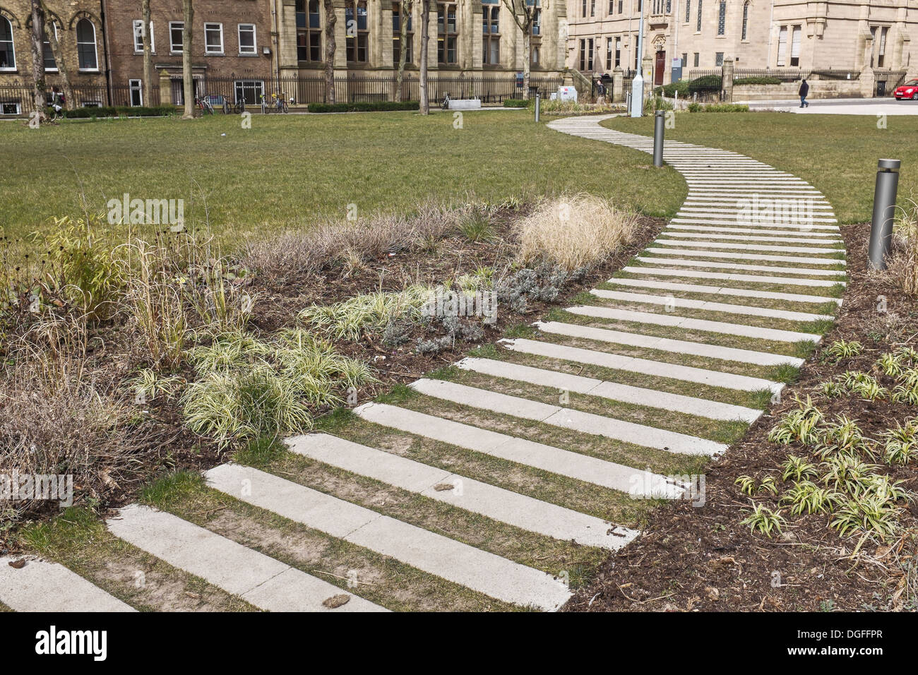 Erba curvo e percorso di pietra di fronte Alan Gilbert Learning Commons, l'Università di Manchester REGNO UNITO Foto Stock