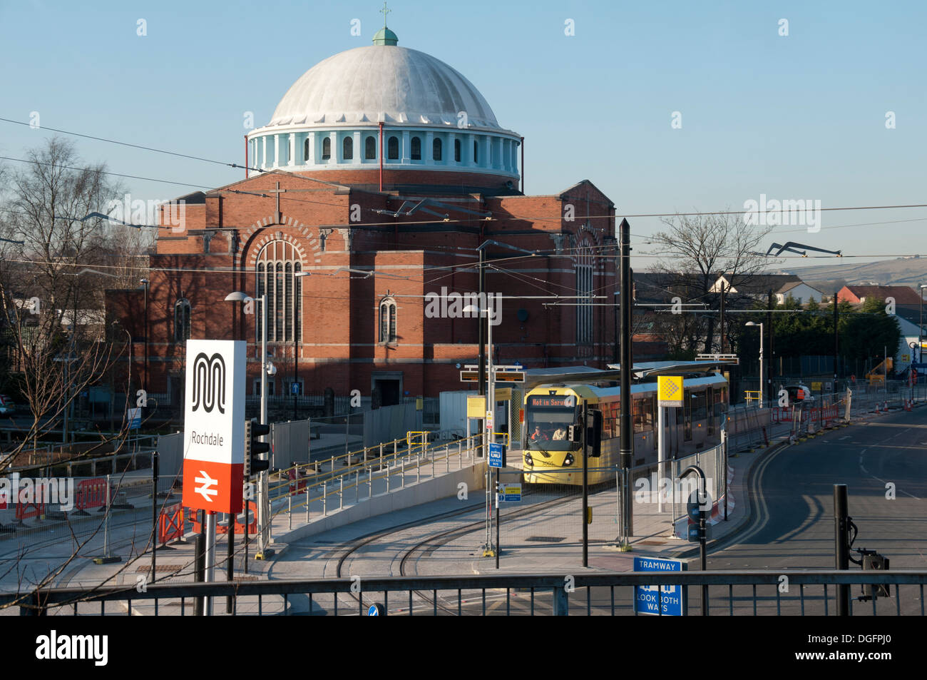Metrolink tram alla stazione ferroviaria fermano a Rochdale, Manchester, Inghilterra, Regno Unito. Chiesa di San Giovanni Battista di dietro. Foto Stock
