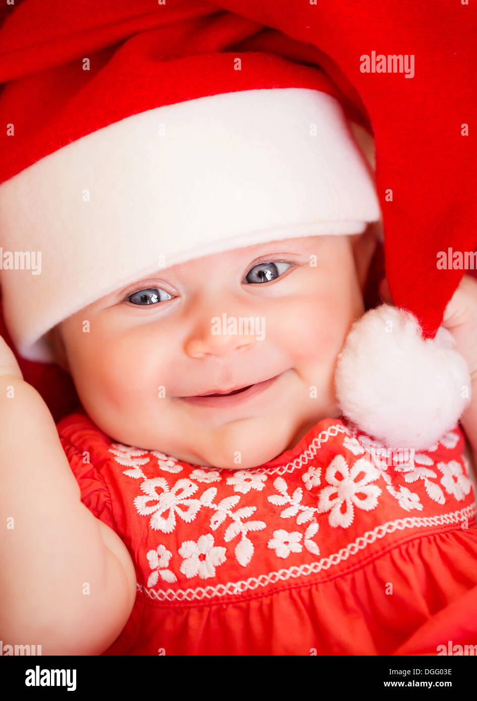 Closeup ritratto della bella neonato indossa red Santa Claus hat, festa di Natale e di Capodanno, concetto di felicità Foto Stock