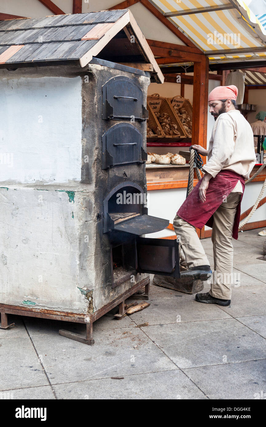 Baker la preparazione di forno per la cottura del pane al suo stallo a l'Oktoberfest, Alexanderplatz Berlino Foto Stock