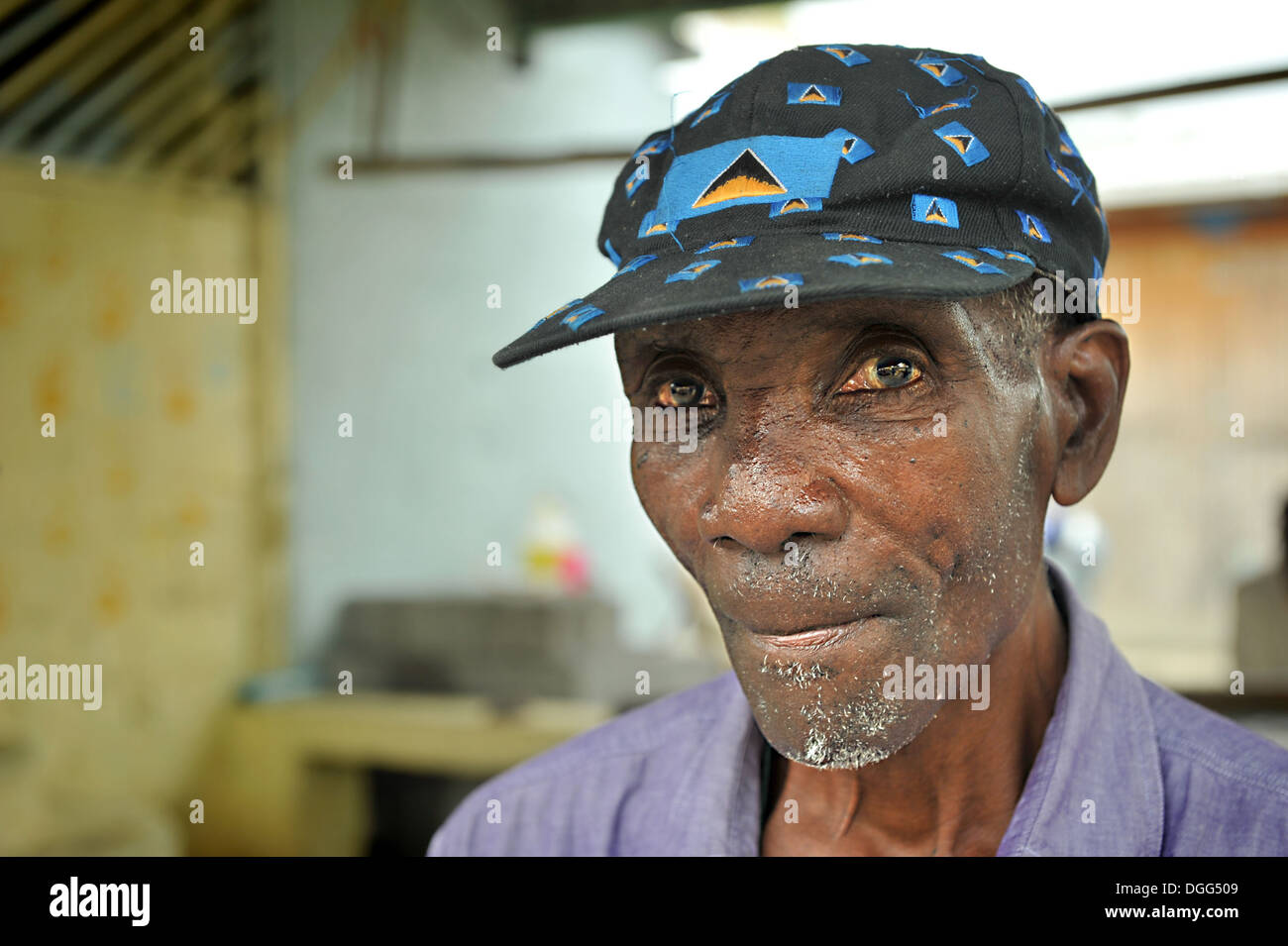 Anziani West Indian man, indossando il berretto da baseball con St.Lucian bandiera blasonata in tutto. Senior Citizen Foto Stock