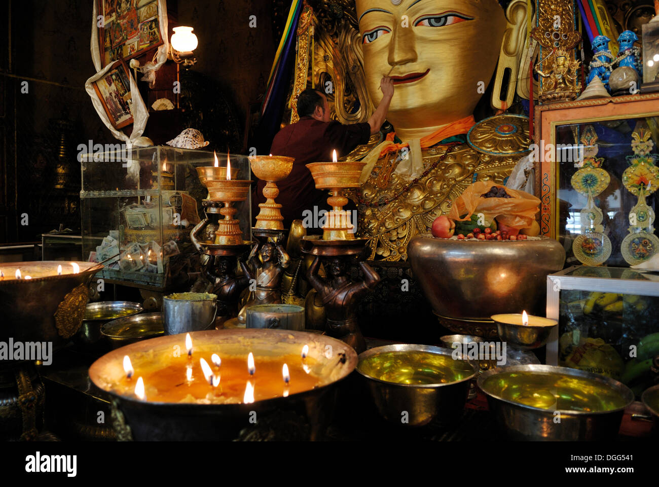 Monaco di fronte a una grande statua del Buddha nel monastero di Drepung, Lhasa, in Tibet, in Cina Asia Foto Stock