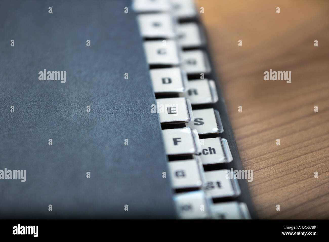 Registro alfabetico su una cartella di nero su un tavolo di legno, la profondità di campo Foto Stock