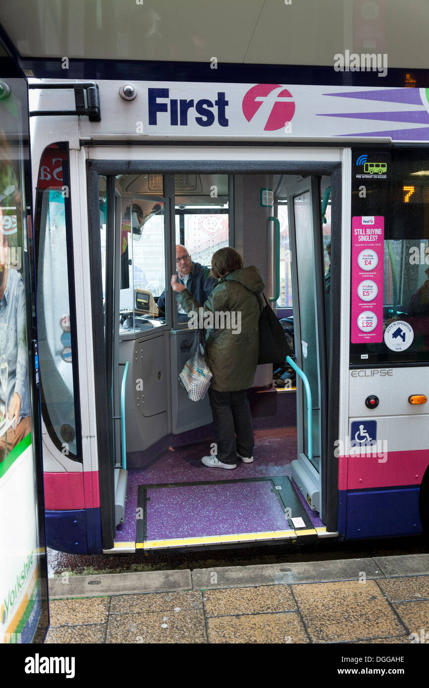 Parlando del passeggero al conducente sul primo bus pubblico presso la fermata degli autobus. Foto Stock