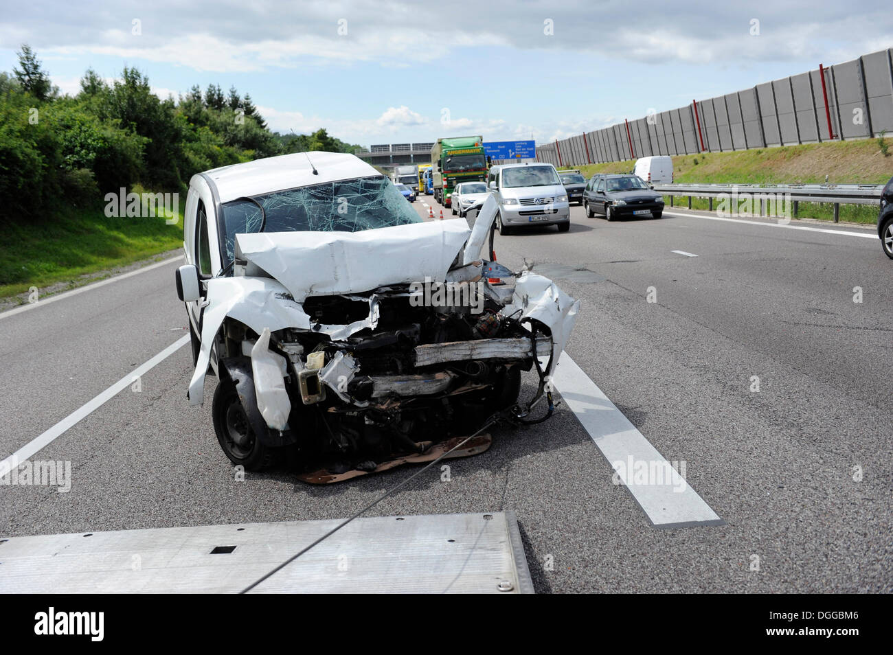 Un pesantemente danneggiata van viene recuperato dopo un incidente sulla A8 strada vicino a Leonberg da un carrello di traino, Baden-Wuerttemberg Foto Stock