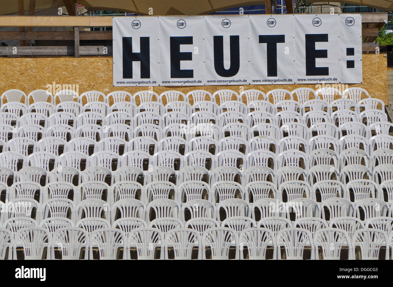 Segno "heute", tedesco per "oggi", e sedie in plastica bianca disposti in righe un concerto all'aperto, area di Dresda Foto Stock