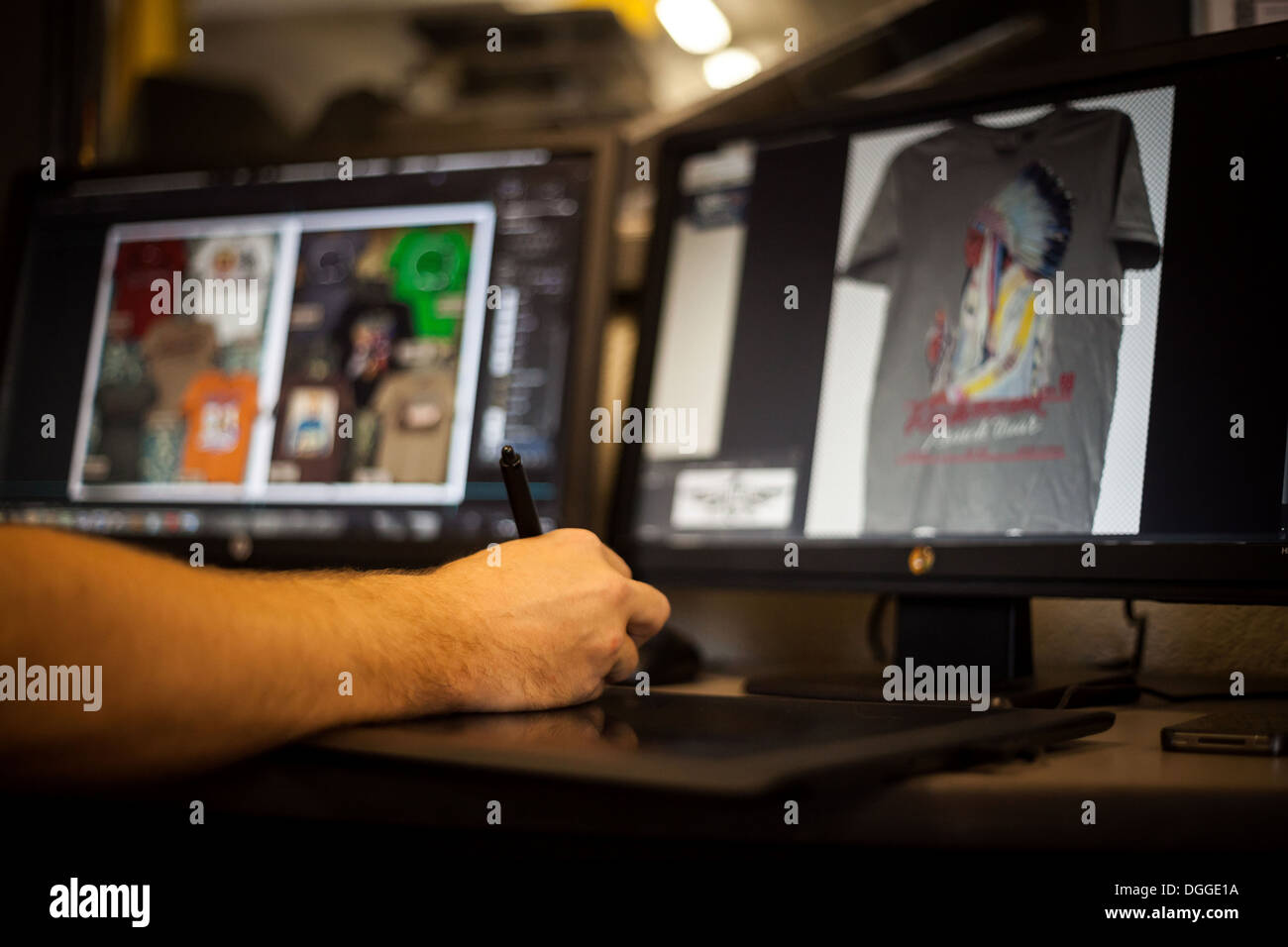 Uomo con tavoletta grafica e penna per la progettazione di t-shirt Foto Stock