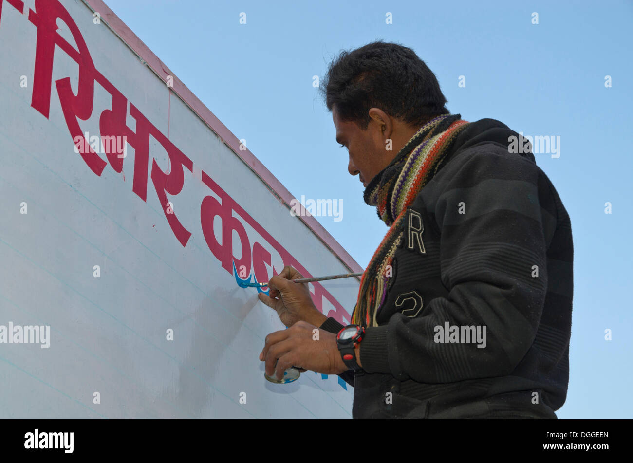 L'uomo pittura red Hindi lettere su una lavagna bianca, Pokhara, Nepal Foto Stock