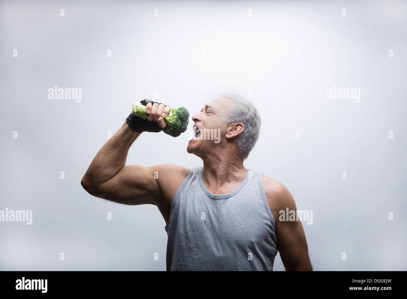 Senior uomo circa per mangiare i broccoli Foto Stock