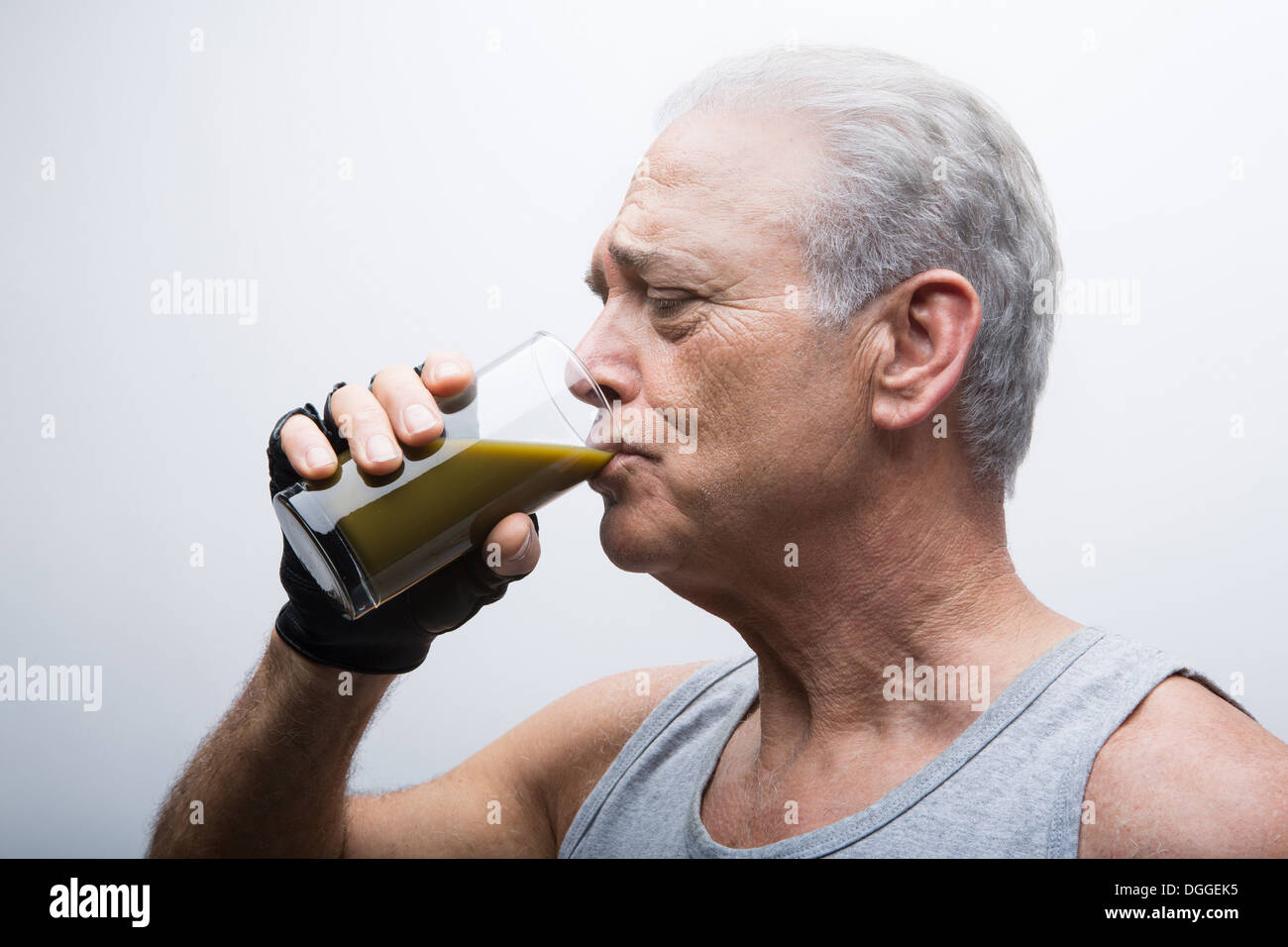 Senior uomo frullato di bere dal bicchiere Foto Stock