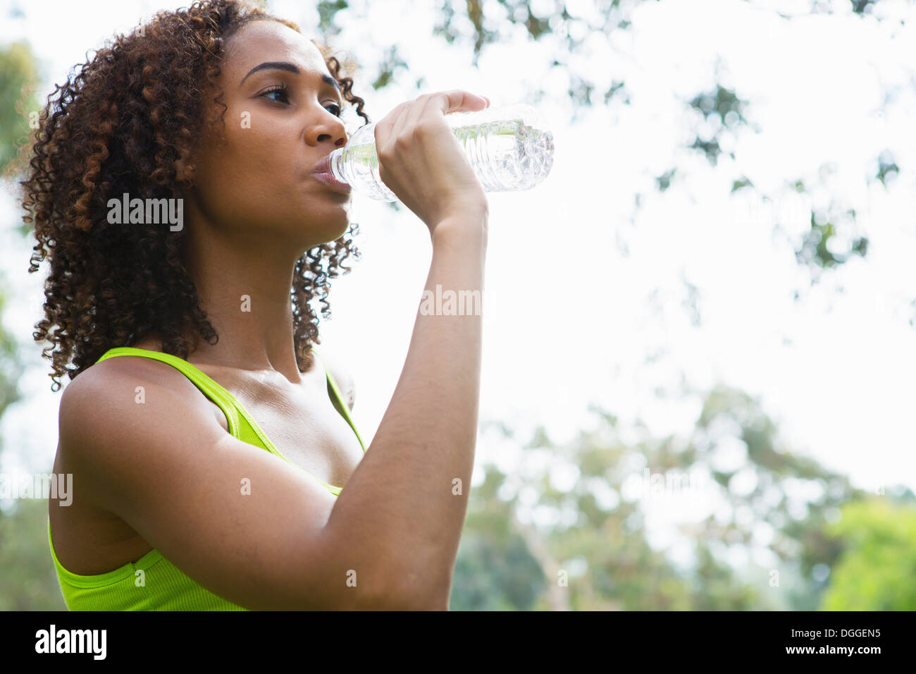 Metà donna adulta bere da una bottiglia d'acqua Foto Stock