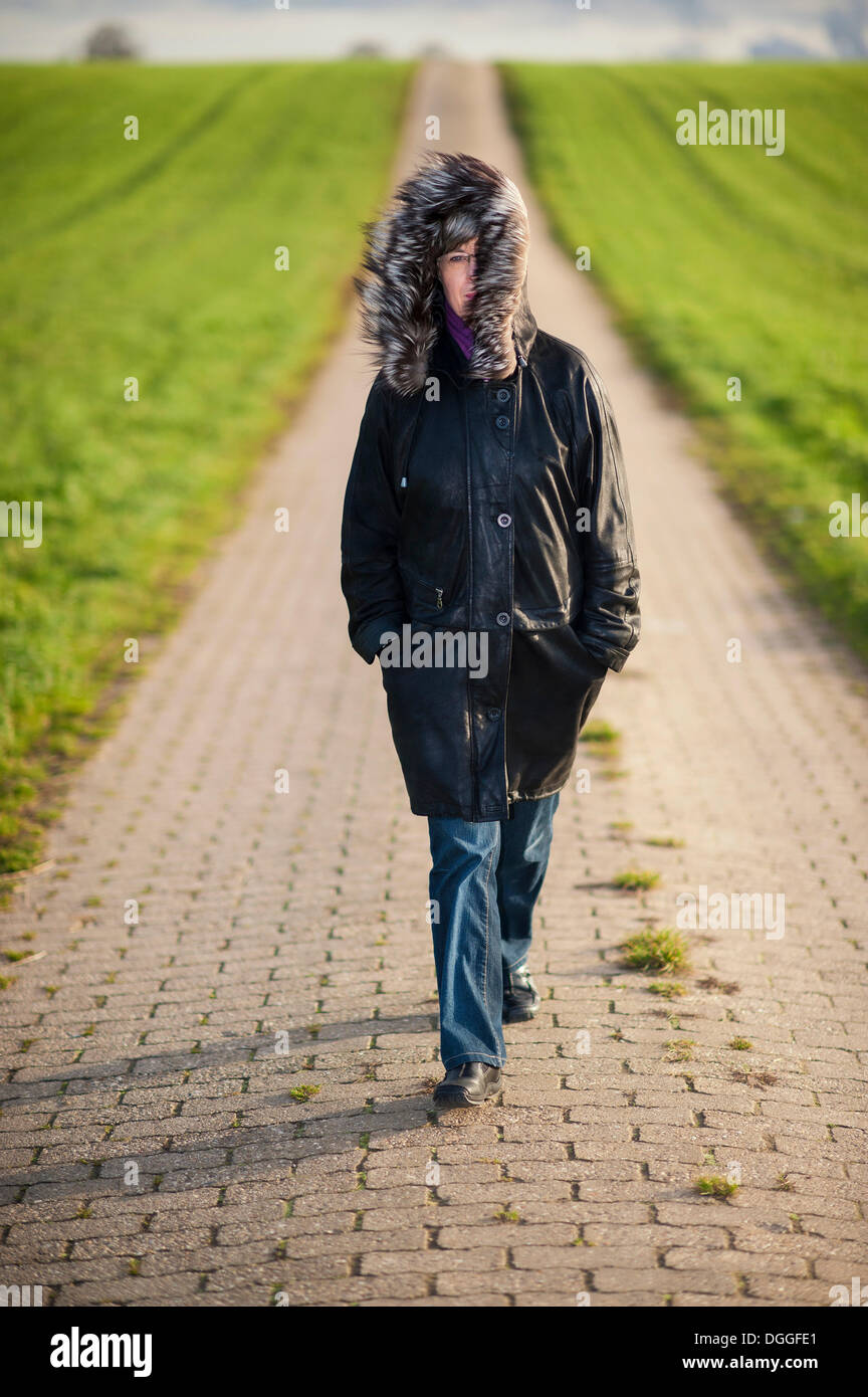 Donna che cammina su un percorso di campo, Grevenbroich, Renania settentrionale-Vestfalia Foto Stock