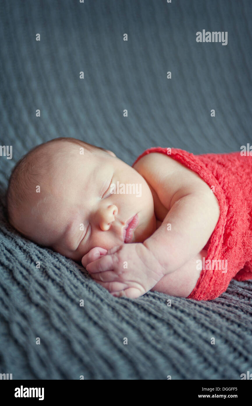 Bambino giacente sulla coperta grigio, dormendo Foto Stock