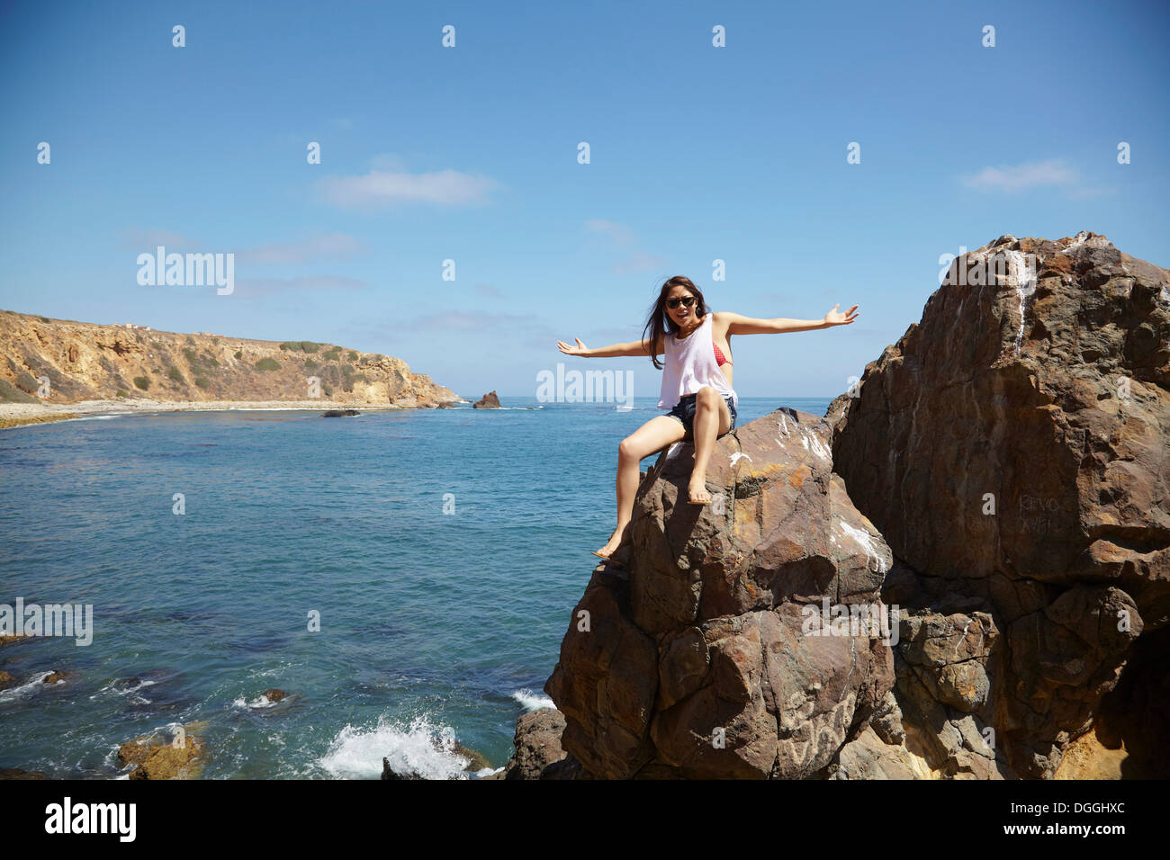 Giovane donna seduta sulle rocce, Palos Verdes, CALIFORNIA, STATI UNITI D'AMERICA Foto Stock