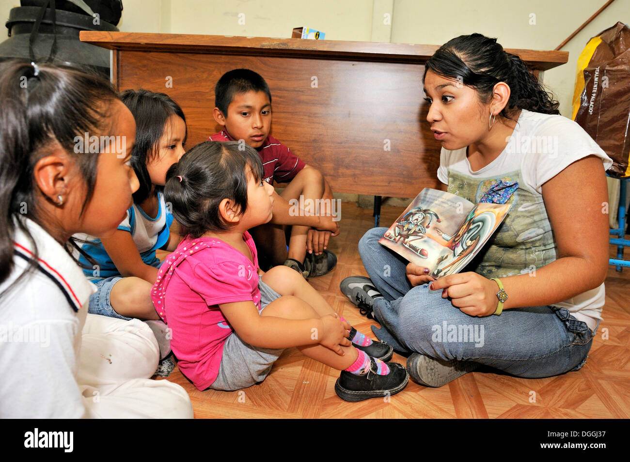 Prodotti per la cura del bambino lavoratore del messicano organizzazione non governativa CIDES la lettura di un libro di fotografia per bambini indigeni in una delle baraccopoli Foto Stock