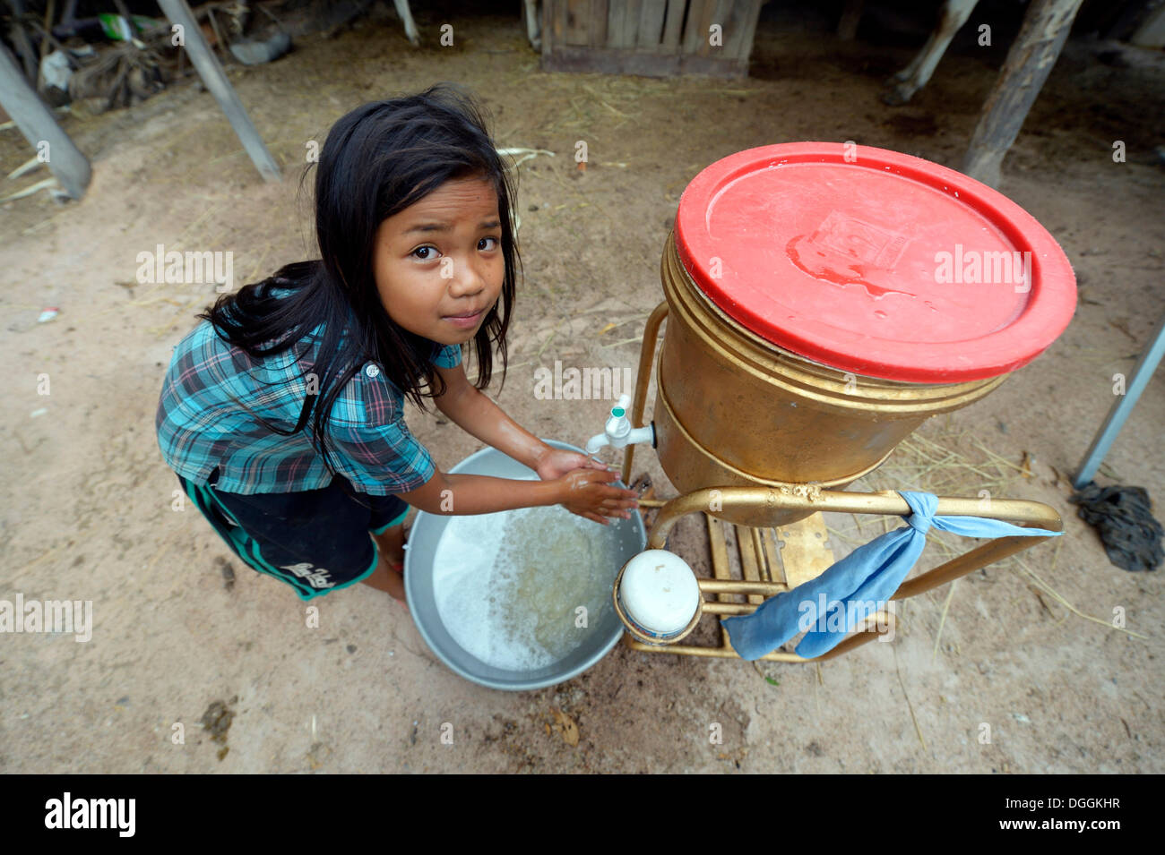 Educazione all igiene attraverso una carità, ragazza lavando le mani, Trapang Village, Bathi Distretto, Provincia di Takéo, Cambogia Foto Stock
