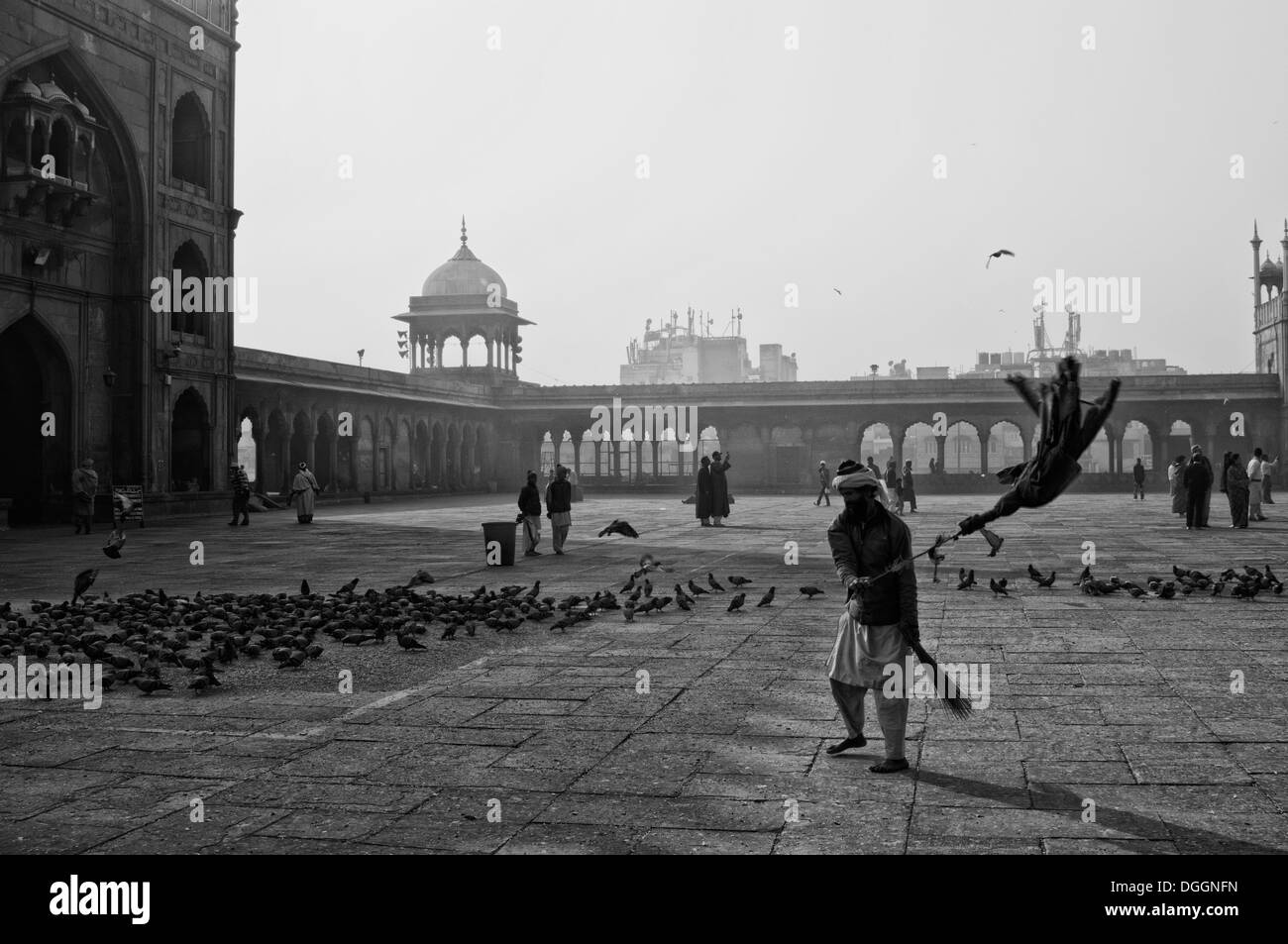 L'uomo hushing allontanamento piccioni in Jama Masjid di Delhi. Foto Stock