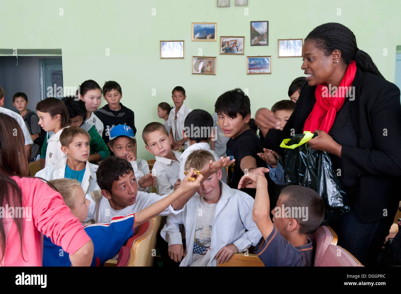 Master Sgt. Donna Jeffries passa fuori caramelle ai bambini di Chui Orphanage-Boarding scuola a Bishkek, Krygyzstan, dopo una prestazione da parte del governo degli STATI UNITI Forze Aeree fascia centrale Blue Yonder prestazioni del 4 ottobre, 2013. Jeffries è il 376 Expeditiona aria Foto Stock