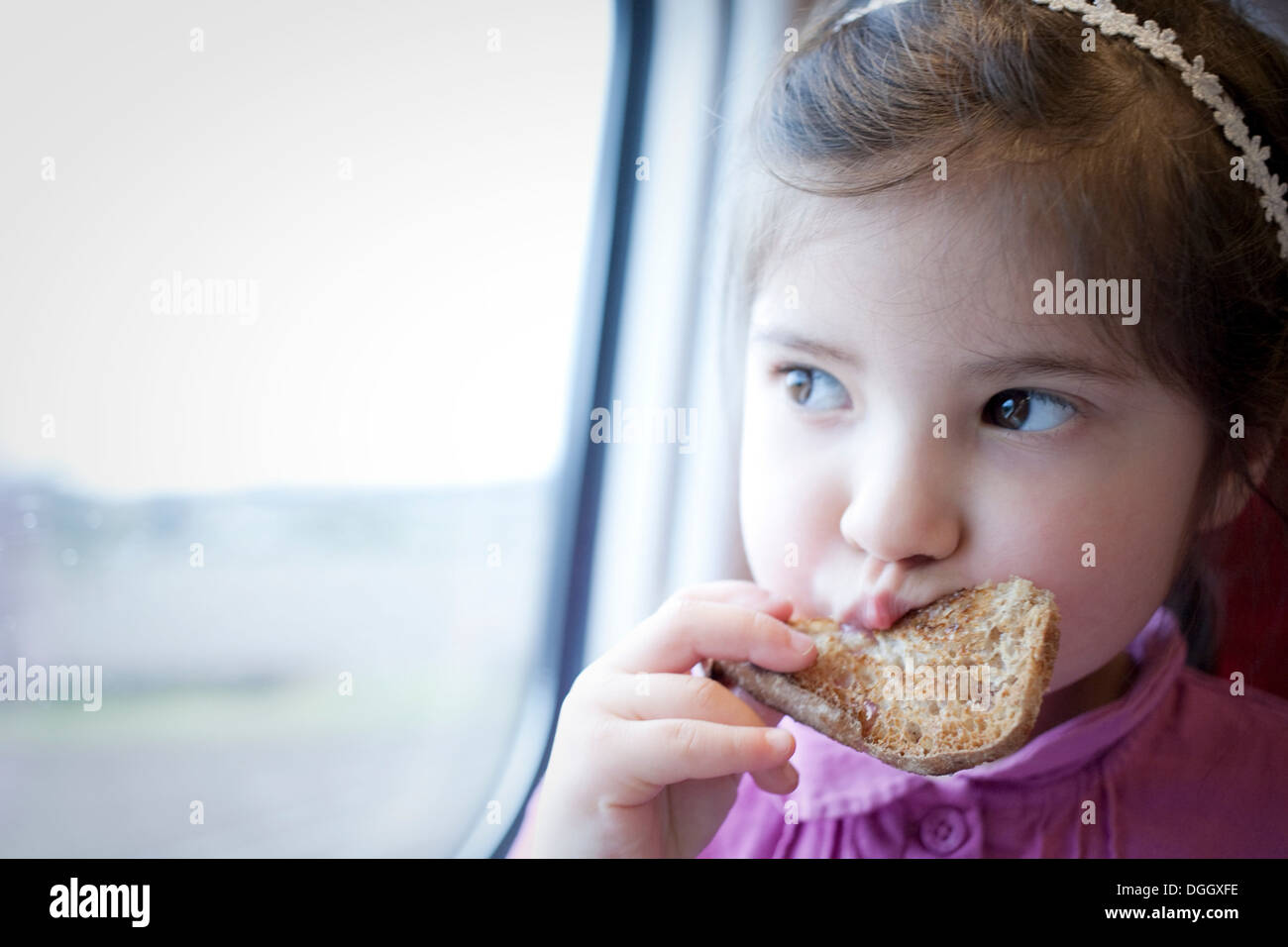 Bambina sul treno, mangiare Foto Stock