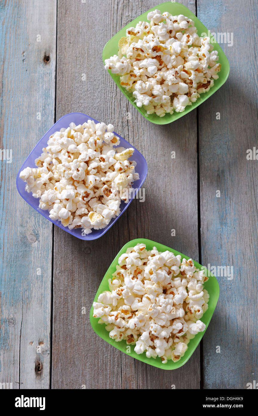 Il Popcorn in ciotole di plastica su sfondo di legno Foto Stock