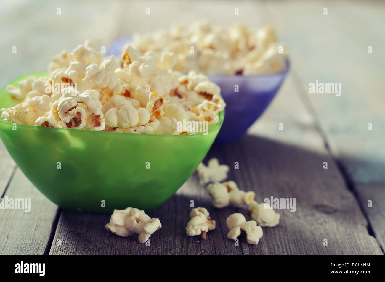 Il Popcorn in ciotole di plastica su sfondo di legno Foto Stock