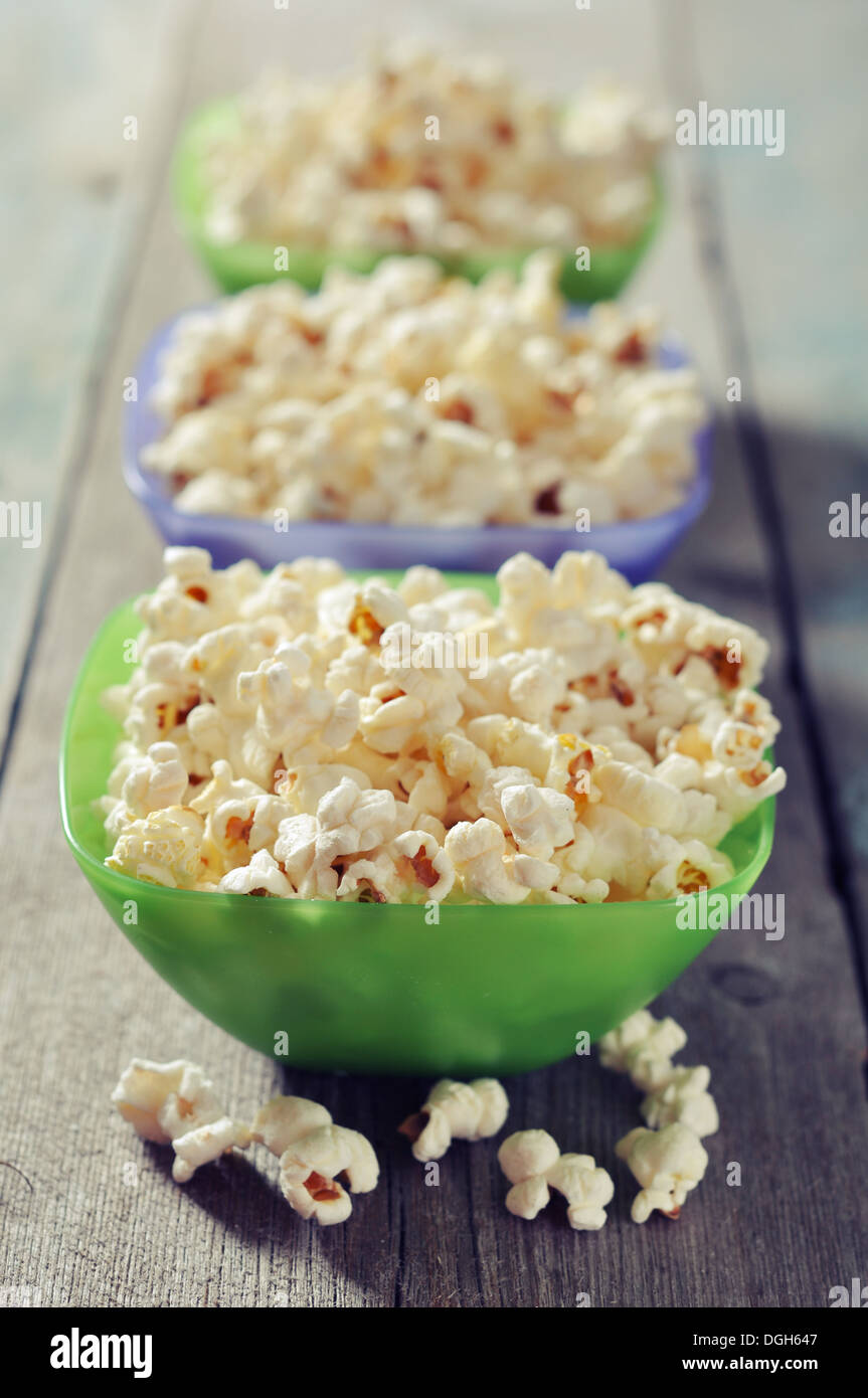 Il Popcorn in ciotole di plastica su sfondo di legno Foto Stock