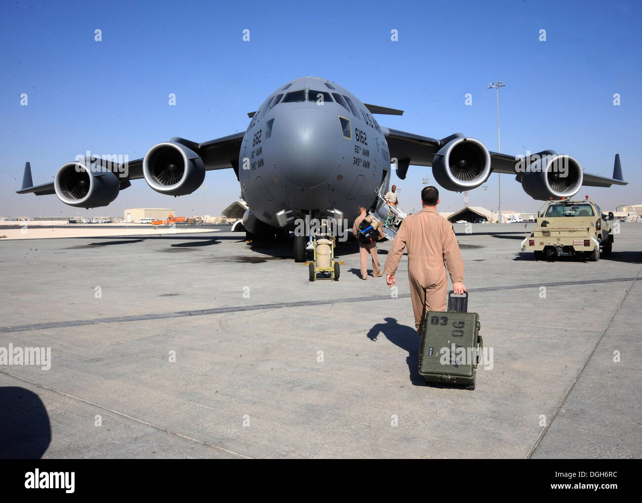 C-17 Globemaster III Equipaggi membri a piedi verso i loro aerei con le attrezzature in mano prima di una missione al 379 Aria ala Expeditionary nel sud-ovest Asia, 13 ottobre, 2013. Il Globemaster III è in grado di rapida erogazione strategica di truppe e tutti ty Foto Stock